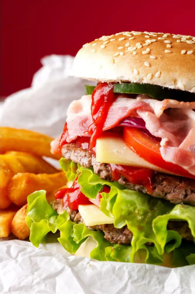 Double patty burger with bacon, cheese, veggies and crispy fries at J Burger n Wings, a Fast - Food Restaurant in Muskegon